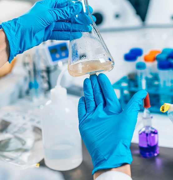 Technik s ochrannými rukavicami stanovuje zákal vody v laboratóriu.